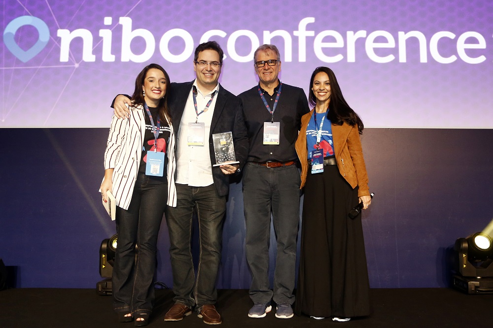 Mariana Miranda (head de Marketing do Nibo), Alvaro Castro (sócio da AEC Contábil), Bernardinho (ex técnico da seleção brasileira de Volei) e Leticia Gabbay (coordenador do Programa de Parceria para contadores do Nibo) estão sobre o palco do Nibo Conference 2018 durante a premiação dos clientes Ouro do Nibo.